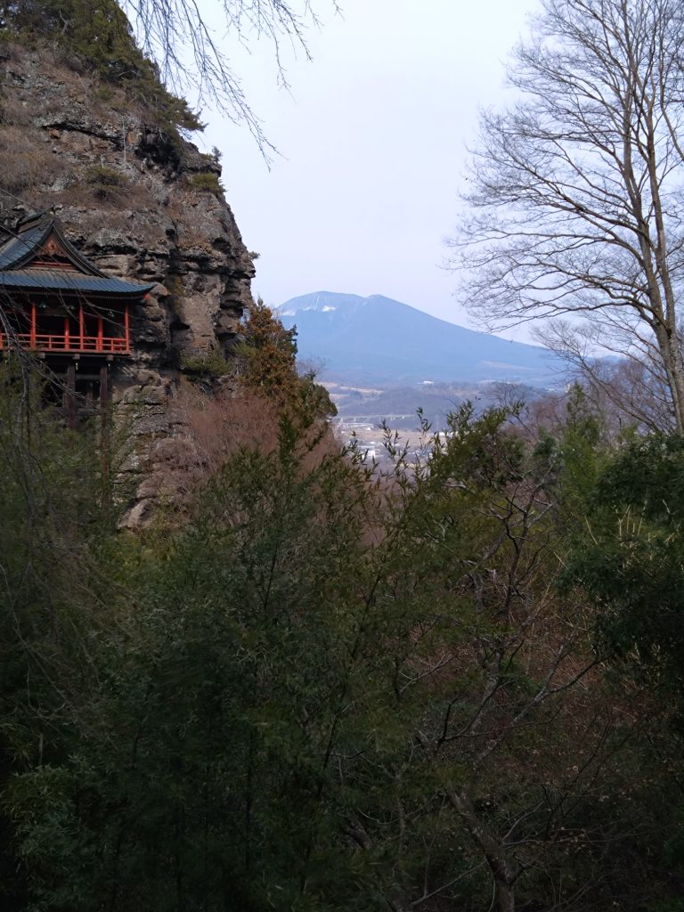 断崖の観音堂と、その向こうに見える浅間山が一つの景色になっている。